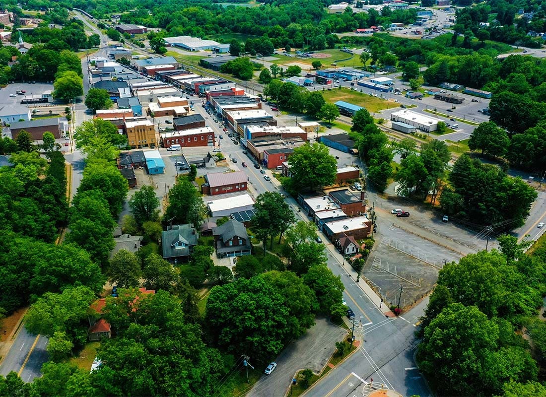 Weaverville, NC - Aerial View of Buildings in Downtown Weaverville North Carolina Surrounded by Green Trees on a Sunny Day
